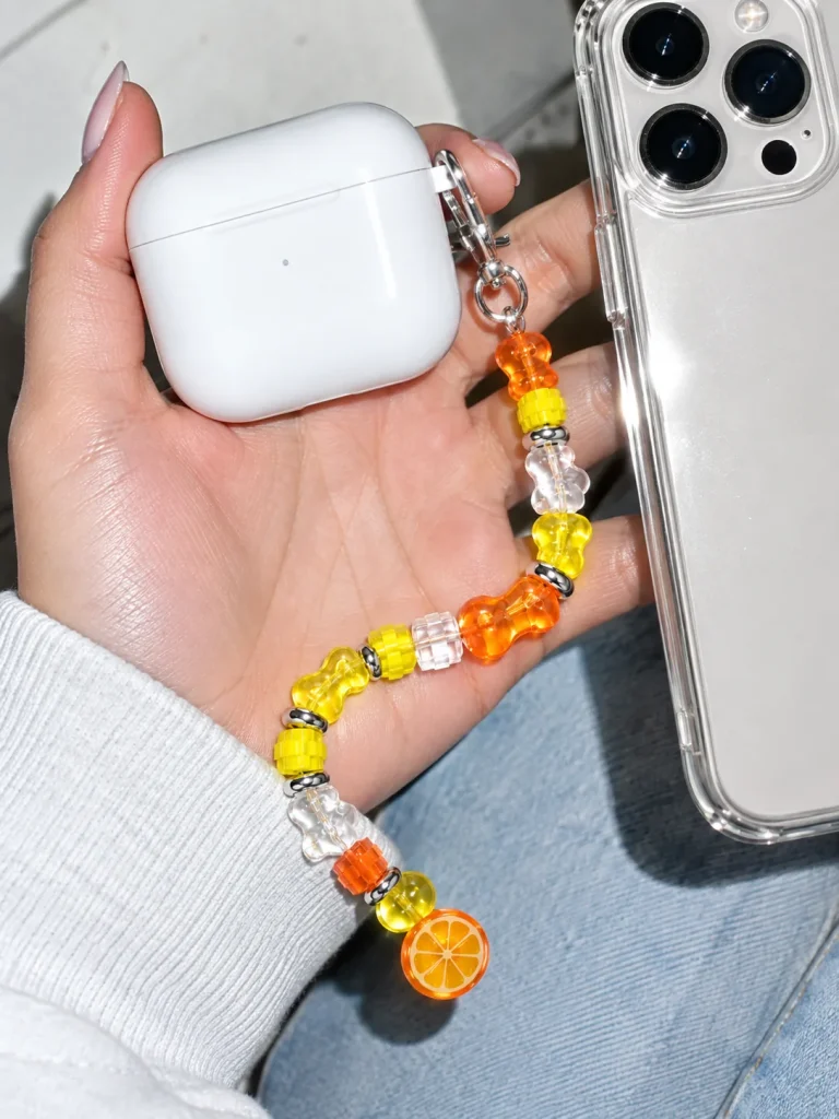 Tangerine Glitch Earbud Case Charm worn or in use